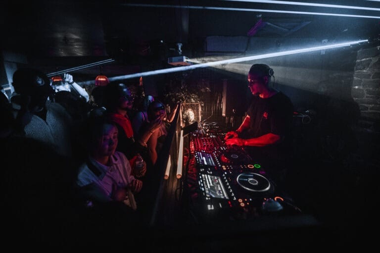 DJ performing to crowd with lasers above