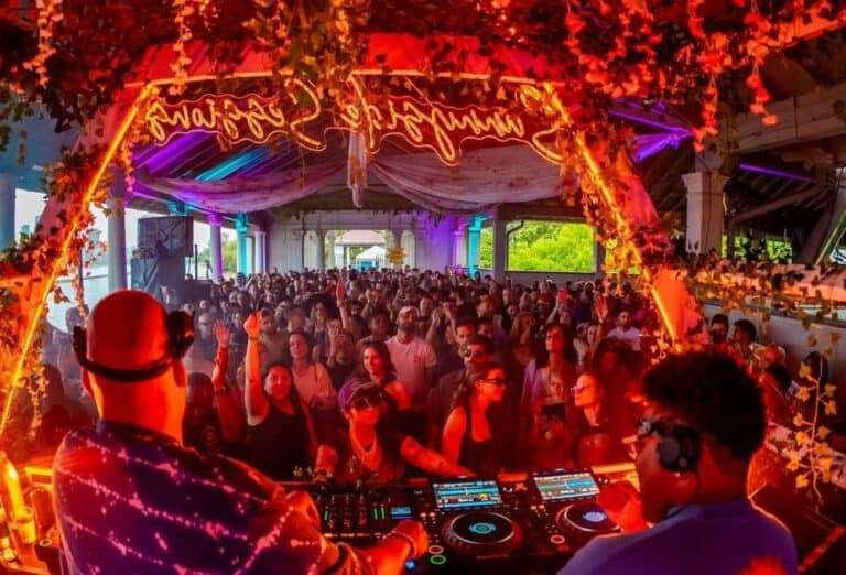 DJs overlooking large red-lit dancefloor at Sunnyside Toronto