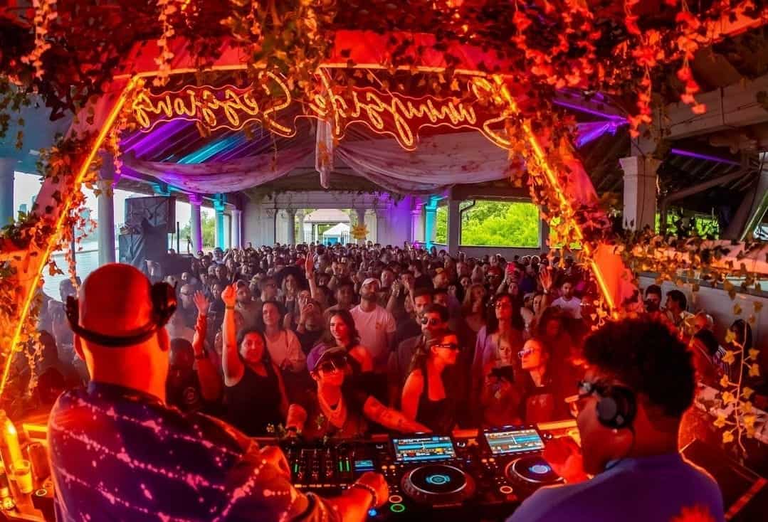 DJs overlooking large red-lit dancefloor at Sunnyside Toronto
