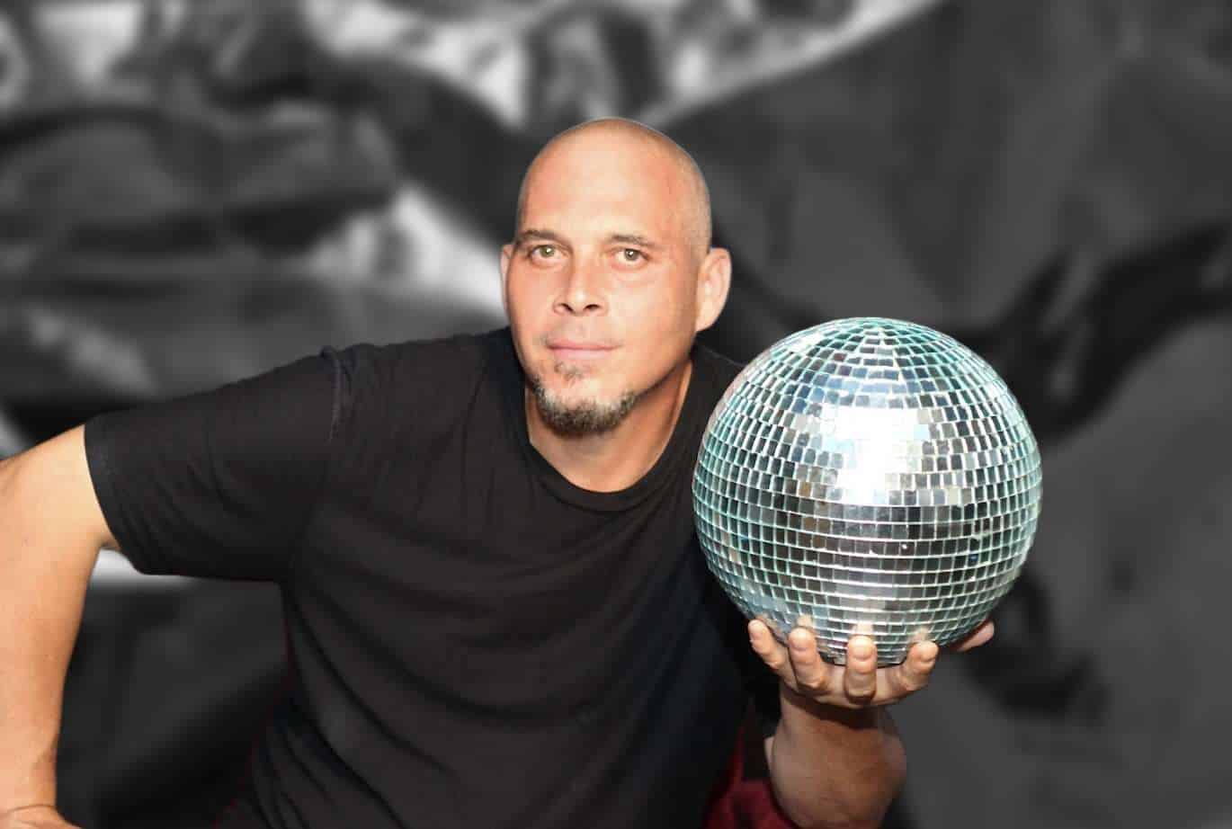Tyler Hill Portrait Dball Crackle Portrait of a bald man holding disco ball