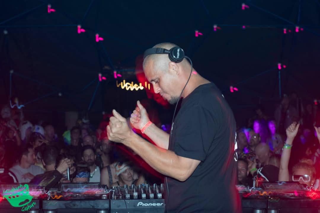 DJ dances to a crowd of onlookers inside a festival geodesic dome